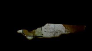 espiando a la becina por un agujero